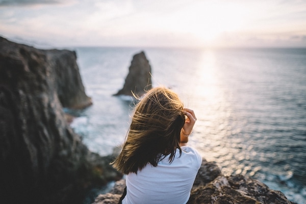 Woman relaxing by the ocean at sunset