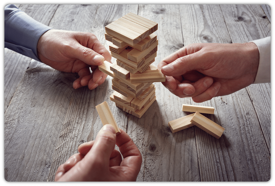 3 hands playing Jenga on wooden table