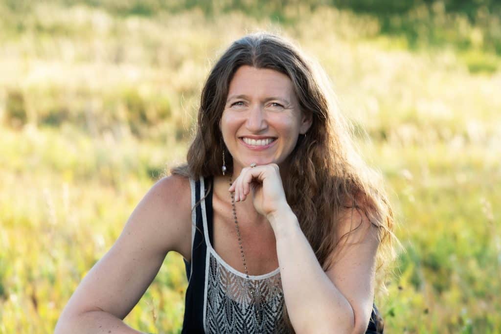 Dr. Arielle Schwartz smiling at camera in a sunny field. EFT Tapping for trauma practitioner